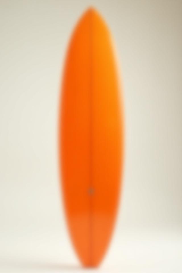 Classic single fin board with a translucent orange tint